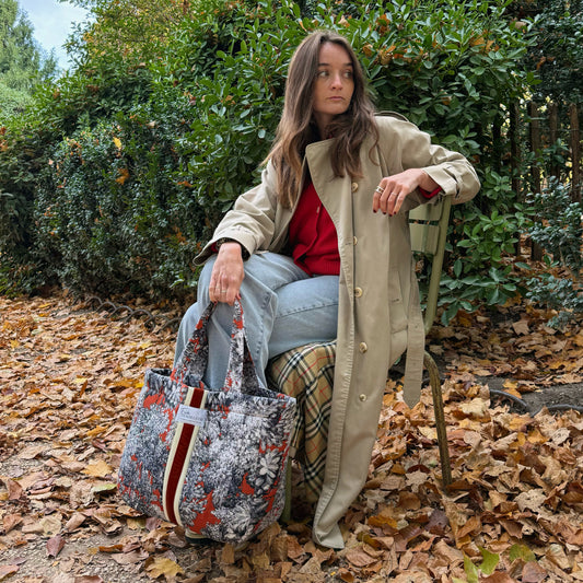 Grand sac cabas en Toile de Jouy couleur terracotta porté à l'épaule dans un jardin Parisen